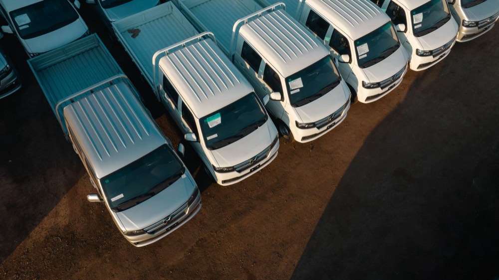 A fleet of white company work vehicles parked in a row