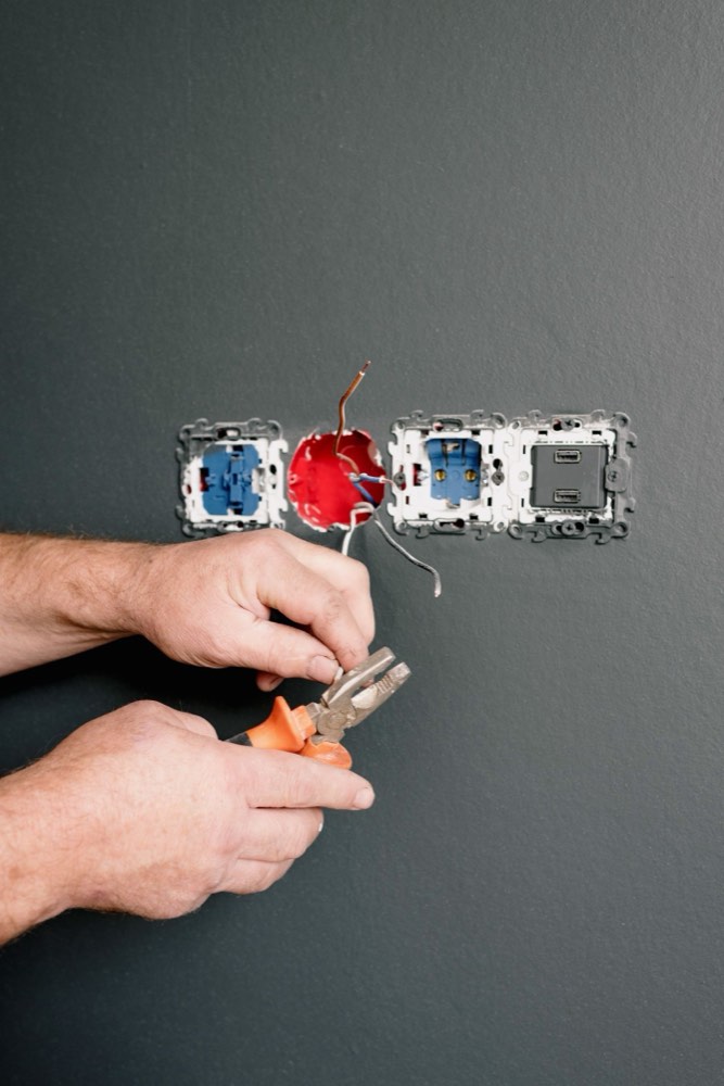 An electrician wiring a bank of power outlets