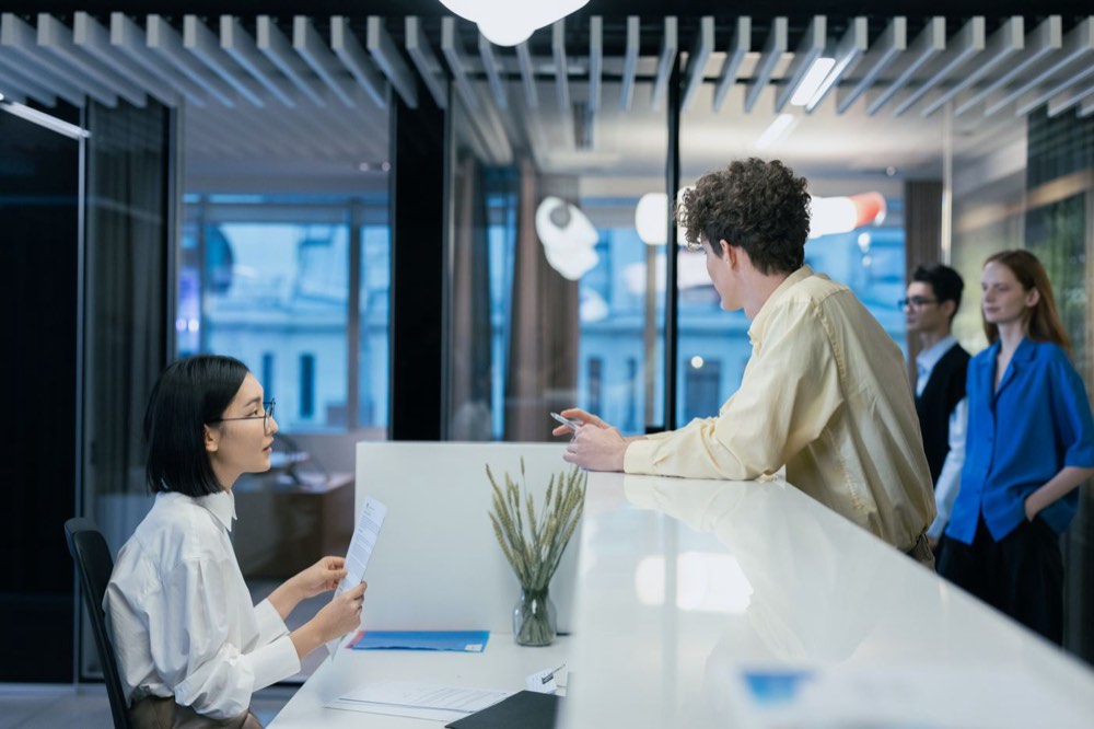 A guest talking with a member of staff across a reception desk