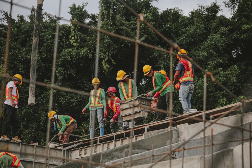 A crew in hard hats and high-visibility vests working on a construction site
